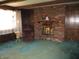 Inviting living room with brick fireplace, wood beams, and comfortable armchair at 7402 Alice Ave, Indianapolis, IN 46219