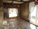 Cozy living area with stone fireplace, wood paneling, tiled floors, and access to the outdoors at 7402 Alice Ave, Indianapolis, IN 46219
