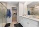 Well-lit bathroom featuring double sinks, tiled shower, and walk-in closet access at 8673 Laurelton Pl, Brownsburg, IN 46112