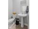 Cozy half bathroom with a pedestal sink, toilet, and minimalist decor at 8673 Laurelton Pl, Brownsburg, IN 46112