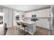 Modern kitchen with an island, stainless steel appliances, white cabinets, and a view of the outside at 8673 Laurelton Pl, Brownsburg, IN 46112