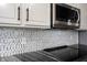 Close up view of stainless microwave, decorative backsplash and granite counter at 8748 N Autumnview Dr, McCordsville, IN 46055