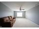 Living room featuring a plush sofa, ceiling fan and neutral paint to create a cozy and inviting space at 8748 N Autumnview Dr, McCordsville, IN 46055