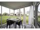 Inviting screened-in porch with a table and chairs overlooking a lush, green backyard at 8748 N Autumnview Dr, McCordsville, IN 46055