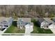 Aerial view of a home showing the roof, lawn, and neighborhood homes with a wooded area at 9207 Foudray N Cir, Avon, IN 46123