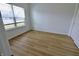 Bright bedroom featuring wood floors, large window, and white walls, offering a serene and spacious feel at 9207 Foudray N Cir, Avon, IN 46123