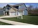 Two-story home with blue siding, white trim, brick accents and a three-car garage at 9207 Foudray N Cir, Avon, IN 46123