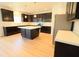 Kitchen with stainless steel appliances, dark cabinets, and center island at 9207 Foudray N Cir, Avon, IN 46123