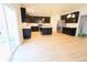 Bright, open kitchen features stainless steel appliances, island with white countertop, and dark cabinets at 9207 Foudray N Cir, Avon, IN 46123