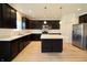 Spacious kitchen with island, stainless steel refrigerator, and dark wood cabinets at 9207 Foudray N Cir, Avon, IN 46123