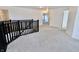 Carpeted landing with dark railing and access to upstairs rooms at 9207 Foudray N Cir, Avon, IN 46123