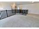 Carpeted landing with dark railing and view of hall at 9207 Foudray N Cir, Avon, IN 46123