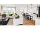 Bright open-concept living room with hardwood floors, modern furniture, and large windows overlooking the yard at 9375 Abner St, McCordsville, IN 46055