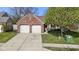 A home's front exterior features a brick facade, two-car garage, and a well-manicured lawn at 9526 Colony Pointe E Dr, Indianapolis, IN 46250