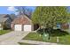 Exterior view of a brick home showcasing its two-car garage and fresh green lawn at 9526 Colony Pointe E Dr, Indianapolis, IN 46250