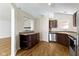 Functional kitchen layout with wood cabinets, bar seating, and stainless dishwasher at 9526 Colony Pointe E Dr, Indianapolis, IN 46250