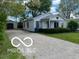 Charming single-story home with a red star, gravel driveway, and detached garage, showcasing curb appeal at 1 Lenora Ave, Indianapolis, IN 46231