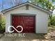 A detached garage with a red door and white siding is perfect for parking or storage at 1 Lenora Ave, Indianapolis, IN 46231
