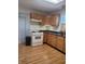 Well-lit kitchen with wood cabinets, durable countertops, modern stove, and laminate flooring at 1 Lenora Ave, Indianapolis, IN 46231