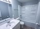 Bright bathroom featuring a tub-shower, modern vanity, and toilet with neutral tile floors at 103 N Nebraska St, North Salem, IN 46165