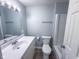 Well-lit bathroom featuring a large vanity, toilet, and bathtub with white walls and modern fixtures at 103 N Nebraska St, North Salem, IN 46165