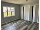 Bedroom with bi-fold closet doors, large window, and attractive wood-look flooring at 103 N Nebraska St, North Salem, IN 46165