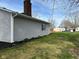 Side view of the house featuring a brick chimney and grassy lawn at 103 N Nebraska St, North Salem, IN 46165