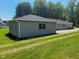 Exterior view of a freshly painted gray home with green grass and surrounding trees on a beautiful day at 103 N Nebraska St, North Salem, IN 46165