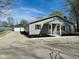 One-story home with a detached two-car garage, gray siding, black shutters, and a gravel driveway at 103 N Nebraska St, North Salem, IN 46165
