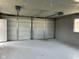 Spacious garage interior with side entry door, two overhead doors and concrete flooring at 103 N Nebraska St, North Salem, IN 46165