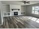Spacious living room with a white brick fireplace and dark gray hardwood flooring at 103 N Nebraska St, North Salem, IN 46165