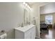 This bathroom features a white sink vanity with a mirror and view of the bedroom at 10881 August Dr, Ingalls, IN 46048