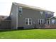A home exterior shot showcases a backyard with a green lawn and a brown siding home with a wooden deck at 11014 Woodpark Dr, Noblesville, IN 46060