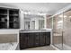 Bright bathroom with a double vanity, walk-in shower, and built-in shelving for storage at 11014 Woodpark Dr, Noblesville, IN 46060