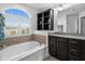 Relaxing bathroom featuring a soaking tub beneath a large window and vanity at 11014 Woodpark Dr, Noblesville, IN 46060