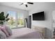Bright bedroom with two windows offering plenty of natural light, a stylish upholstered bed, and modern furniture at 11014 Woodpark Dr, Noblesville, IN 46060