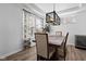 A dining room area featuring hardwood floors, gray curtains, and modern style lighting at 11014 Woodpark Dr, Noblesville, IN 46060