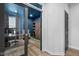View of a home office from an interior hallway, featuring a modern desk, sliding-door cabinet, and sports decor at 11014 Woodpark Dr, Noblesville, IN 46060