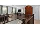 Upstairs landing with dark wood railing and carpeting, leading to a seating area and bedroom at 11014 Woodpark Dr, Noblesville, IN 46060