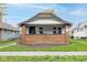 Charming bungalow with a cozy brick porch and a well-maintained front lawn at 1116 N Linwood Ave, Indianapolis, IN 46201