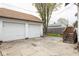 Two-car garage and parking pad featuring wood paneled doors and access to outdoor stairs at 1116 N Linwood Ave, Indianapolis, IN 46201