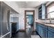 Traditional kitchen with blue cabinets, wood countertops, stainless steel refrigerator, and black floors at 1116 N Linwood Ave, Indianapolis, IN 46201
