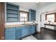 Open kitchen featuring blue cabinets, butcher block countertops, stainless steel dishwasher, and black hardwood floors at 1116 N Linwood Ave, Indianapolis, IN 46201