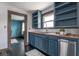Classic kitchen with blue cabinetry, butcher block countertops, stainless steel dishwasher, and black hardwood floors at 1116 N Linwood Ave, Indianapolis, IN 46201