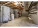 Spacious unfinished basement with concrete walls, exposed pipes, shelving, and mechanicals, ready to be customized at 12304 Ridgeside Rd, Indianapolis, IN 46256