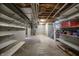 Unfinished basement features concrete floor, exposed pipes, and shelving for plenty of storage and customization at 12304 Ridgeside Rd, Indianapolis, IN 46256