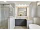 This bathroom offers a modern vanity, an illuminated mirror, a soaking tub, and a glass shower at 12304 Ridgeside Rd, Indianapolis, IN 46256