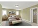 Comfortable bedroom with a queen bed, bench, and natural light from two windows at 12304 Ridgeside Rd, Indianapolis, IN 46256