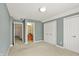 Carpeted bedroom with ensuite featuring view of vanity, with neutral paint and trim throughout at 12304 Ridgeside Rd, Indianapolis, IN 46256