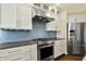 Well-equipped kitchen featuring stainless steel appliances and stylish white cabinetry at 12304 Ridgeside Rd, Indianapolis, IN 46256